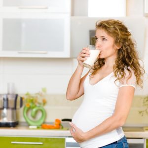 Беременная девушка пьет молоко
